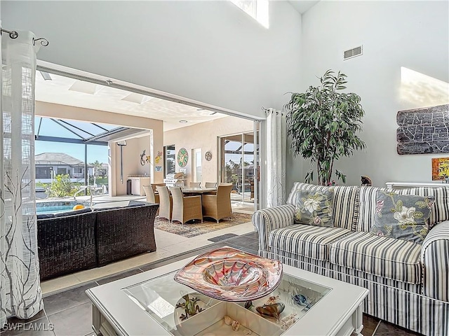 tiled living room featuring a healthy amount of sunlight and a high ceiling