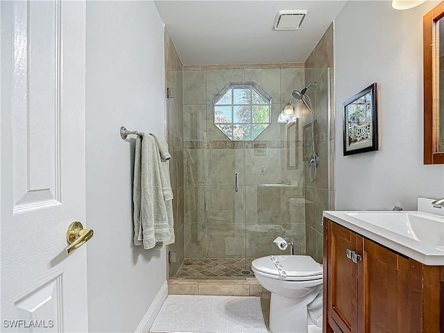 bathroom featuring tile patterned floors, vanity, toilet, and a shower with shower door