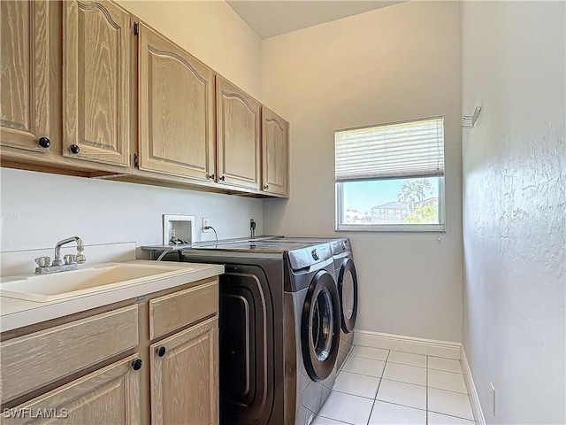 laundry area featuring light tile patterned flooring, cabinets, sink, and washing machine and clothes dryer