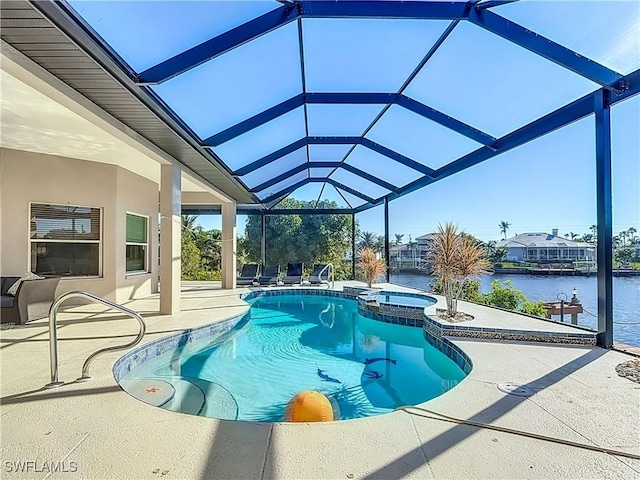 view of pool featuring glass enclosure, a patio area, an in ground hot tub, and a water view