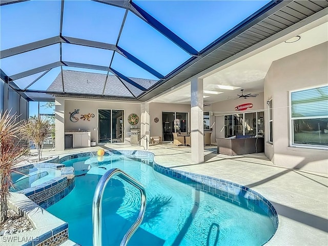 view of swimming pool featuring an in ground hot tub, a patio, glass enclosure, and ceiling fan