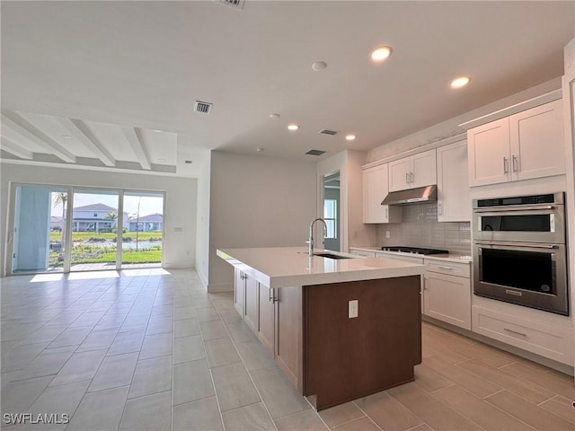 16349 Preservation Blvd, Punta Gorda, FL 33982 - kitchen with open floor plan, double oven, recessed lighting, a center island with sink, and black cooktop