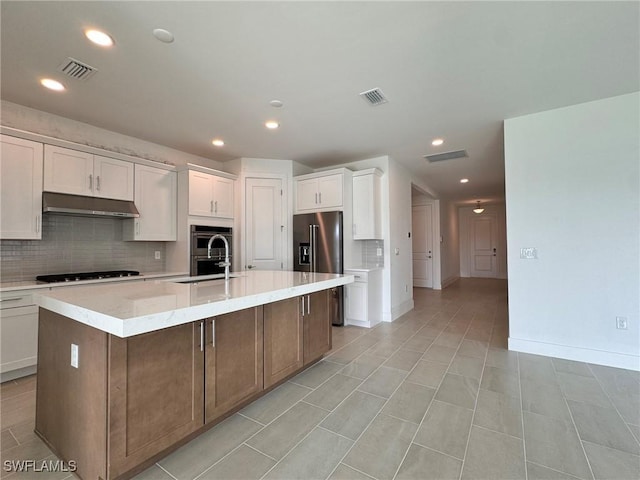 16349 Preservation Blvd, Punta Gorda, FL 33982 - kitchen with appliances with stainless steel finishes, under cabinet range hood, decorative backsplash, white cabinetry, and recessed lighting