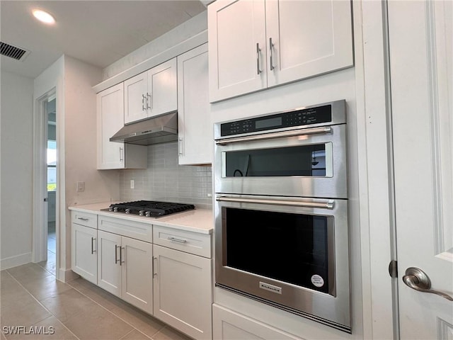 16349 Preservation Blvd, Punta Gorda, FL 33982 - kitchen with appliances with stainless steel finishes, under cabinet range hood, backsplash, light tile patterned floors, and light countertops