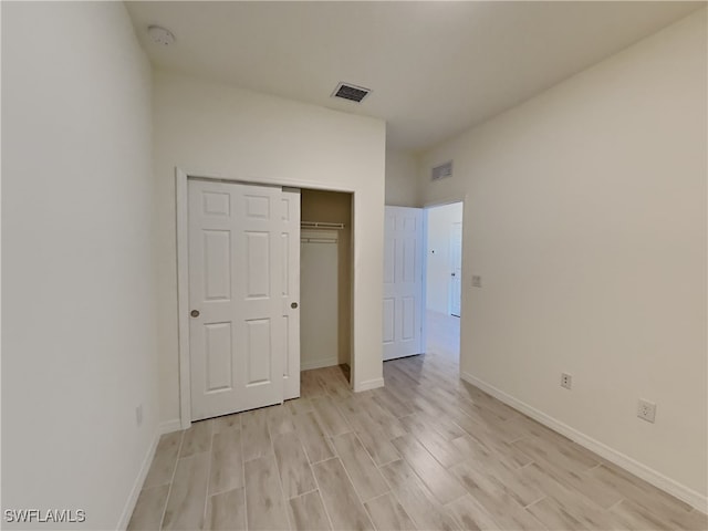 unfurnished bedroom featuring light hardwood / wood-style flooring and a closet