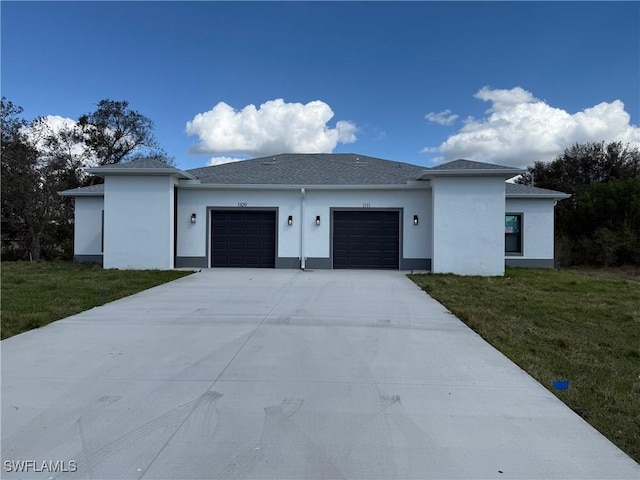 view of front facade with a garage, concrete driveway, and a front yard