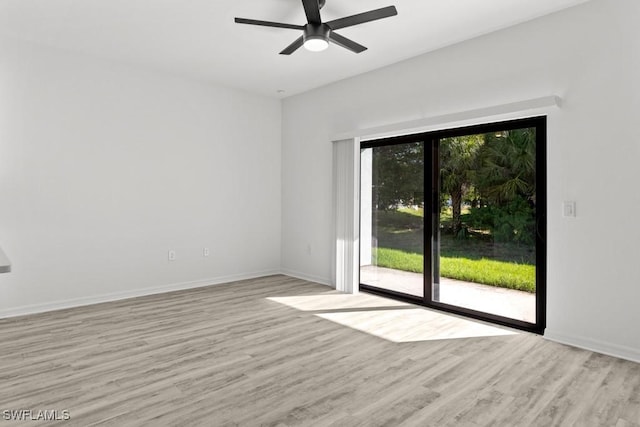 empty room featuring a healthy amount of sunlight, baseboards, and wood finished floors