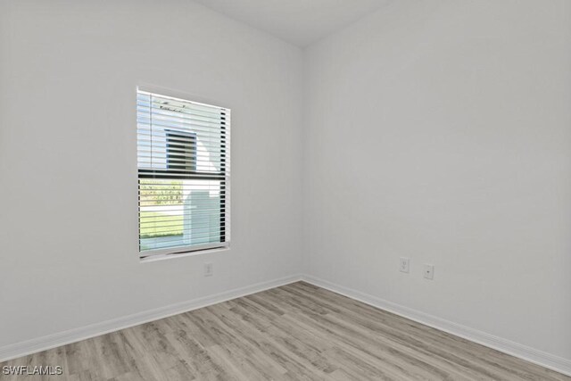 unfurnished room with light wood-style flooring and baseboards