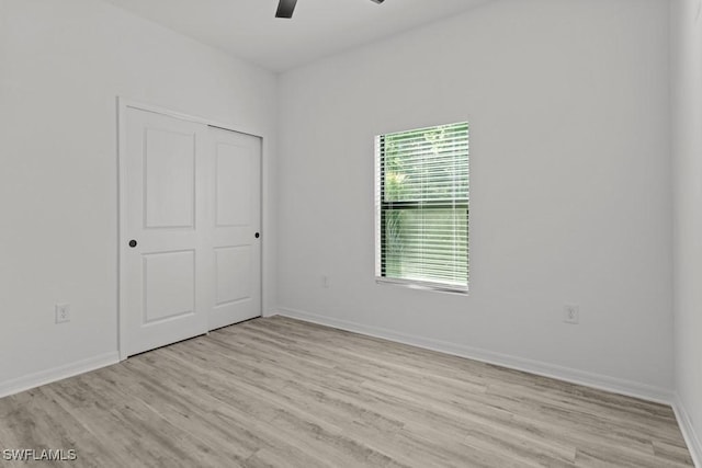 empty room with light wood-type flooring, baseboards, and a ceiling fan