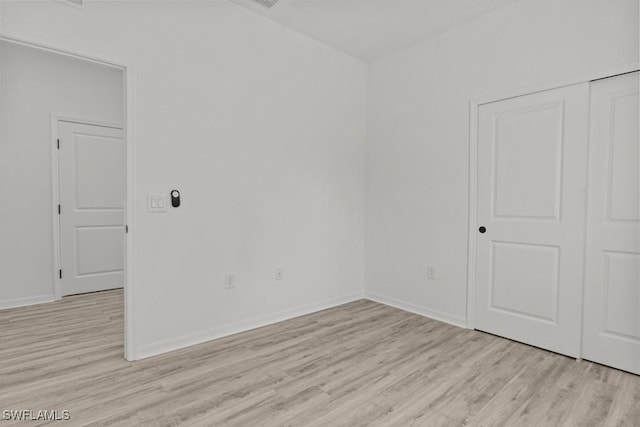 empty room with light wood-type flooring and baseboards