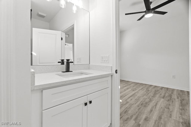 bathroom featuring ceiling fan, baseboards, wood finished floors, and vanity