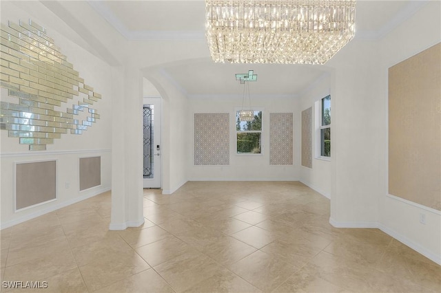 interior space with light tile patterned floors, ornamental molding, and a notable chandelier