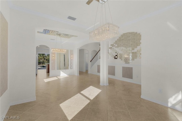 empty room featuring crown molding, light tile patterned floors, and a chandelier