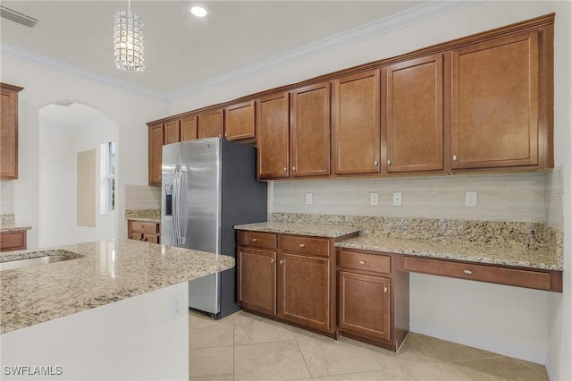 kitchen featuring light stone countertops, stainless steel fridge with ice dispenser, hanging light fixtures, and ornamental molding