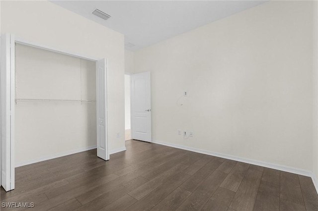 unfurnished bedroom with a closet and dark hardwood / wood-style flooring