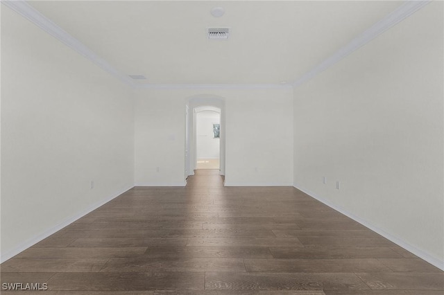 empty room with dark hardwood / wood-style flooring and ornamental molding