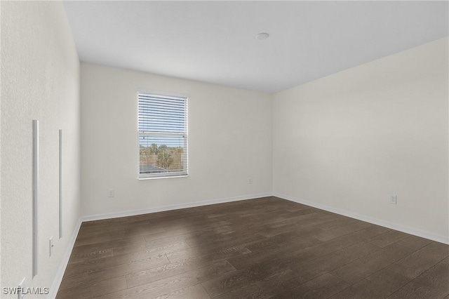 unfurnished room with dark wood-type flooring