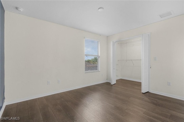 unfurnished bedroom featuring a closet and dark hardwood / wood-style floors