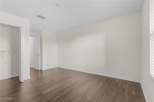 unfurnished bedroom featuring a closet and dark hardwood / wood-style floors