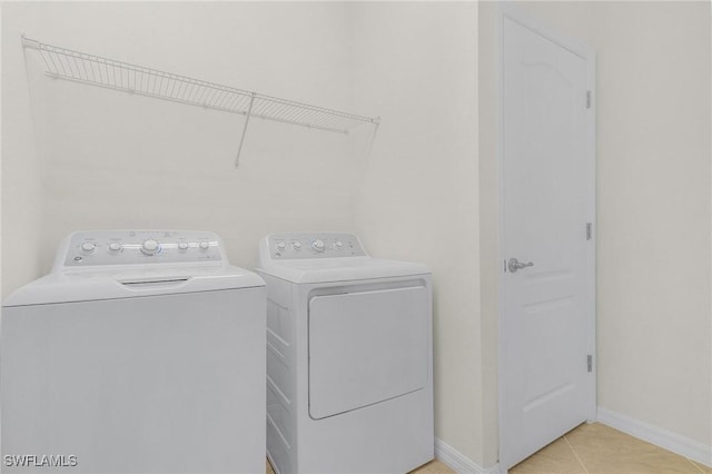 laundry room featuring washing machine and dryer and light tile patterned floors