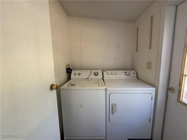 washroom with a textured ceiling and washing machine and clothes dryer