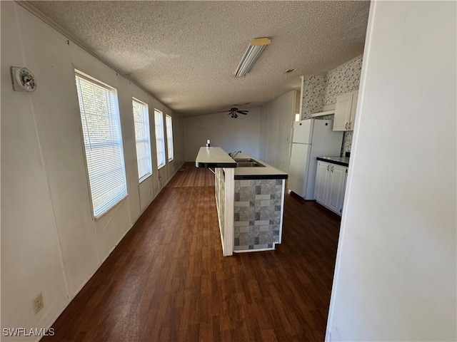 kitchen featuring white refrigerator, dark hardwood / wood-style flooring, white cabinetry, and sink