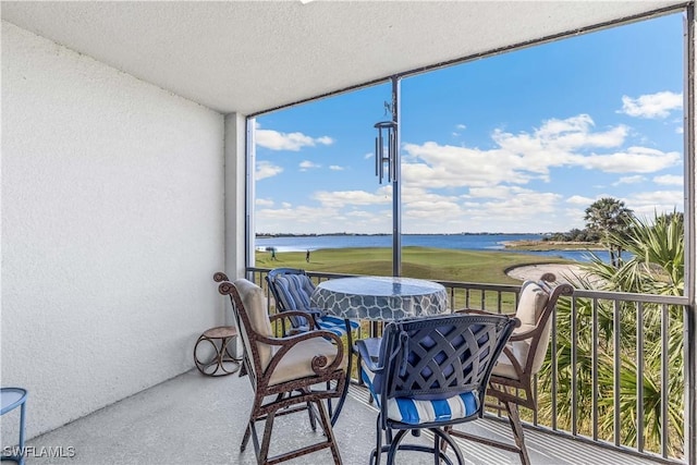 sunroom / solarium with a water view and a healthy amount of sunlight