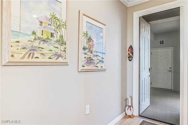 hall featuring light hardwood / wood-style floors and ornamental molding