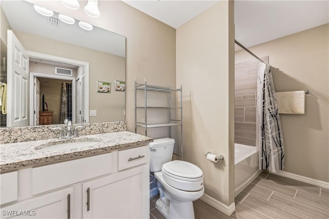 full bathroom with shower / tub combo with curtain, vanity, and toilet