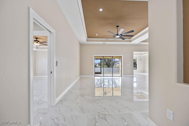 empty room featuring a raised ceiling and crown molding