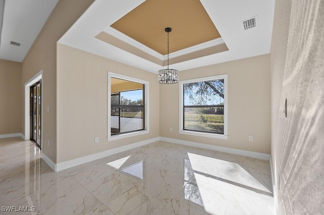 unfurnished dining area with a raised ceiling, ornamental molding, and a chandelier