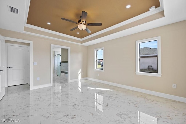 unfurnished room featuring a tray ceiling, ceiling fan, and ornamental molding