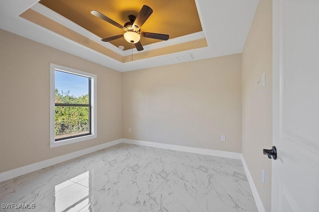 empty room featuring a raised ceiling, crown molding, and ceiling fan