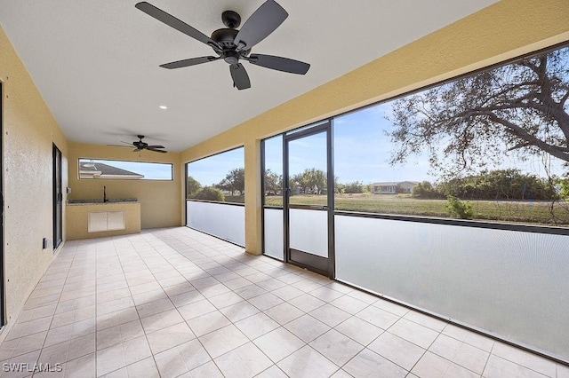 unfurnished sunroom with ceiling fan