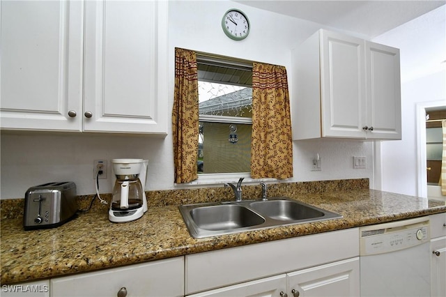 kitchen featuring dark stone countertops, white cabinetry, dishwasher, and sink