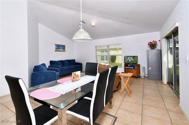 tiled dining space featuring lofted ceiling