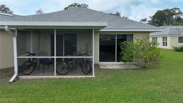 rear view of house with a lawn and a sunroom