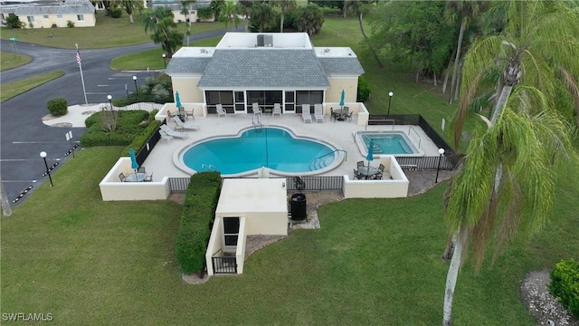 view of swimming pool with a sunroom and a patio area