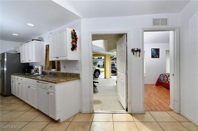 kitchen featuring sink, light hardwood / wood-style flooring, dishwasher, white cabinetry, and stainless steel refrigerator