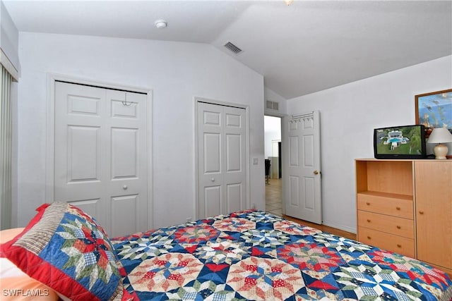 tiled bedroom with two closets and vaulted ceiling