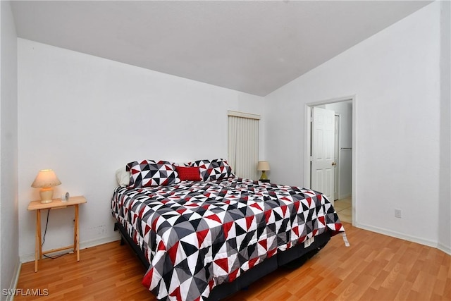 bedroom featuring light hardwood / wood-style flooring and lofted ceiling