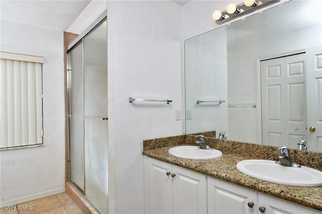 bathroom featuring tile patterned floors, vanity, and a shower with door