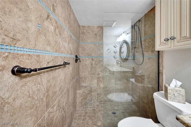 bathroom featuring a tile shower and toilet