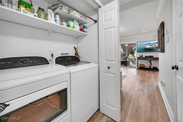 laundry area featuring light hardwood / wood-style floors, separate washer and dryer, and ornamental molding