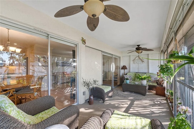 sunroom featuring ceiling fan with notable chandelier