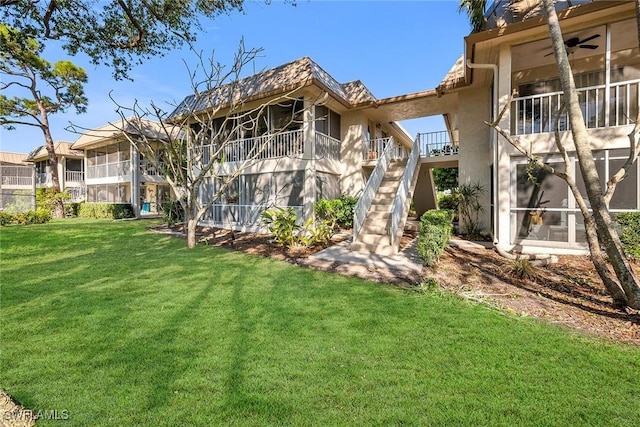 back of property featuring a lawn and a sunroom