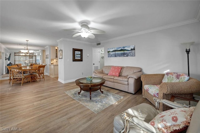 living room with ceiling fan with notable chandelier, light wood-type flooring, and ornamental molding