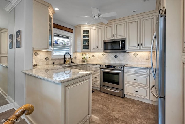 1549 Sandpiper St Unit 80, Naples, FL 34102 - kitchen with stainless steel appliances, decorative backsplash, a peninsula, light stone countertops, and recessed lighting