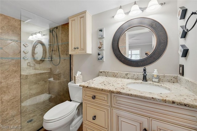 bathroom featuring tiled shower, vanity, and toilet