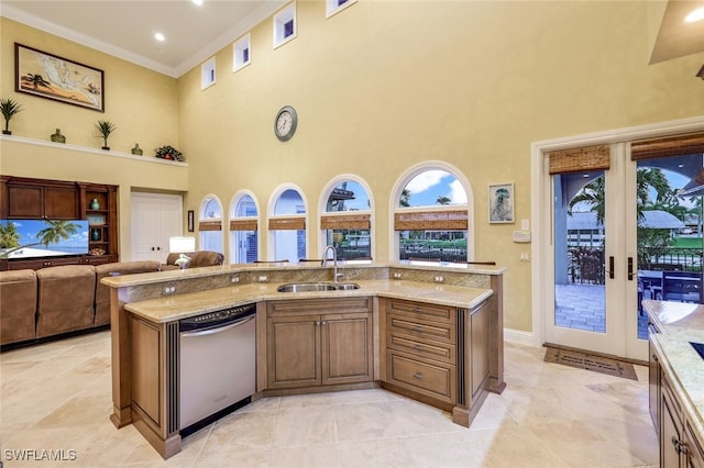 kitchen with light stone countertops, a high ceiling, stainless steel dishwasher, and sink